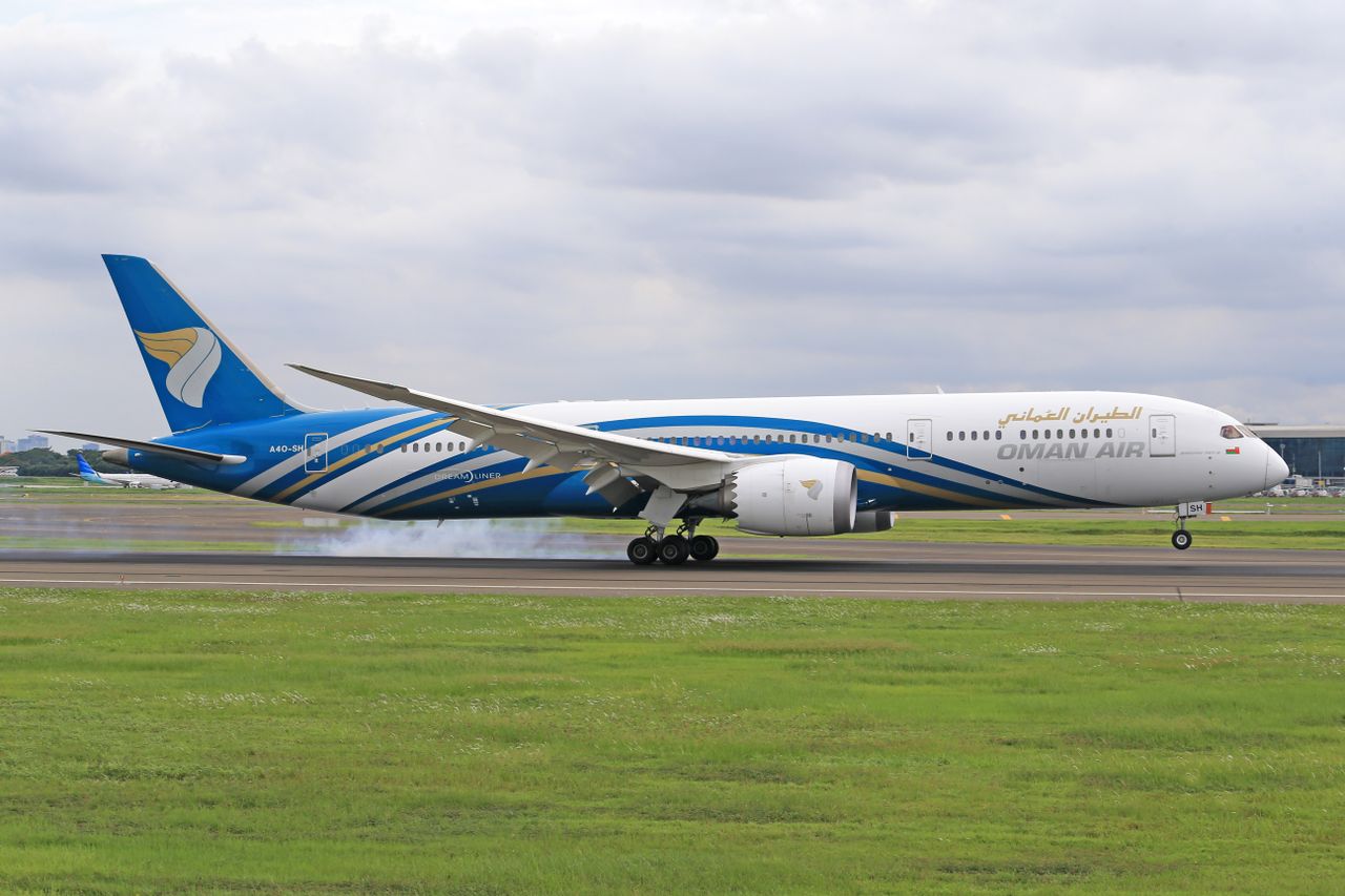 Oman Air Boeing 787 Dreamliner prepares for takeoff on a cloudy day.